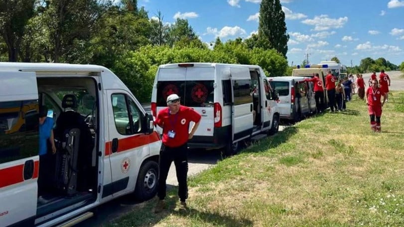Flera bussar från Röda Korset står uppradade för att ta människor till säkerhet under en evakuering i Charkiv, Ukraina.
