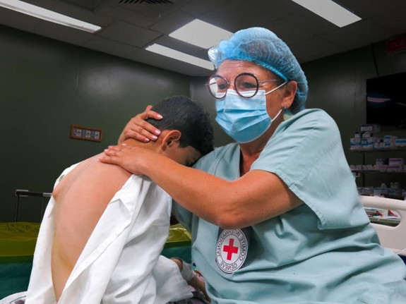 A child in the arms of a Red Crescent volunteer