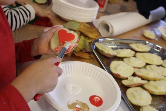 Lek och pyssel på verksamheten träffpunkt familj. Ett barn gör stämplar med hjälp av potatis. 